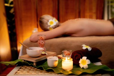Lüks spa salonlarında sıcak mum ışığında cilt bakımı yaptıran kadın müşteri. Sağlık Spa vücut fırçasında tuz temizleme güzellik tedavisi. Sessiz.