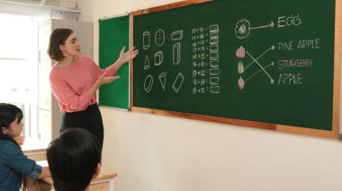 Zeki öğretmen sınıfta fikri açıklarken sevimli öğrenci ödevlerini kontrol ediyor. Not defterine bakıp matematik teorisinden çocuğa bahsederken sınıfta dolaşan çekici bir eğitmen. Pedagoji.