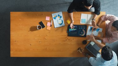 Yönetici, toplantı odasındaki meslektaşlarına mali grafiği açıklar. Farklı pazarlama ekibinin tabletle masada otururken fikir ve planlama stratejisini en üst düzeyde paylaşması. Cemaat.