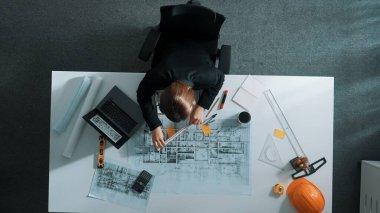 Yapışkan notlar ve hesap makinesiyle bina inşaatı için dizüstü bilgisayar üzerinde çalışırken çalışan mimar mühendisi. Akıllı yönetici plan hesaplamak için hesap makinesi kullanıyor ve çalışıyor. Hizalama.