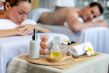 Aromaterapi masajı gündüz atmosferinde ya da spa salonunda bulanık bir kadına odak dekor ve spa aksesuarları kurarak tatil köyünde ya da otel arka planında keyifli aroma spa masajı yapan bir masaj. Sessiz.