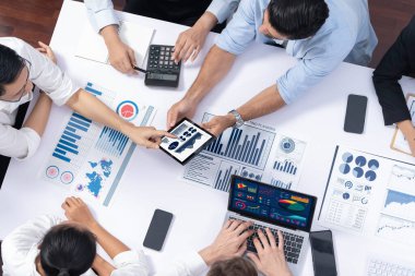 Üst düzey analist ekibi toplantı odasındaki mali verileri analiz etmek için BI Fintech 'i kullanıyor. İş anlayışı ve stratejik pazarlama planlaması için kağıt üzerinde analitik BI gösterge paneli. Tedbirli