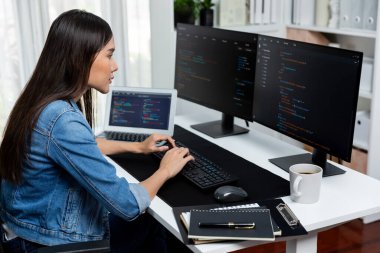İnternet sitesi uygulamasının kodlama verileriyle birlikte online bilgi yazarak kot gömlek giyen genç Asyalı geliştirici. Güvenlik analizi ile çevrili iki ekran. Taktik.