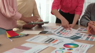 Grafik tasarımı için beyin fırtınası yapan ve renk seçimi yapan yavaş çekim tasarımcısı takımı ya da tasarımcı bürosunda krom danışmanlığı tavsiye isteyen bir müşteri. Değiştirilmiş