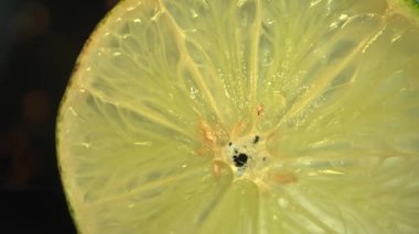 Bir limonun içine yakın çekim. Et kireç soluk sarı-yeşil bir renktir, kabuğun yanında daha koyu yeşil alanlar vardır. Canlı narenciye detaylarının büyüleyici keşfi. Limon dilimi. Geliştirilebilir.