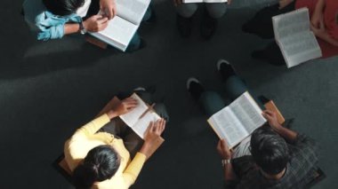 Katlanmış eller yaparken, kucağında haçla İncil okuyan duaların en üstteki görüntüsü. İnanç, güven ve umutla Tanrı 'ya dua eden farklı insanların havadan görünüşü. Ve daireler çizerek oturuyor. Sempozyum.