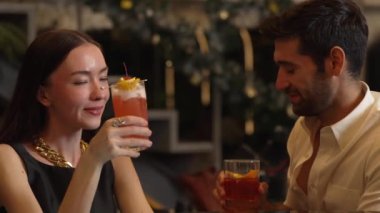 Gülümseyen güzel bir kadın, Paloma kokteyli ile kadeh kaldırıyor. Eski moda, zevkli ve zevkli bir çiftin bardaki özel gece kulübü partisinde canlı sohbetin tadını çıkarıyor. Vinosity.