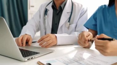 Hastane masasında birlikte çalışan ve tıbbi tedavi planlayan çeşitli profesyonel sağlık görevlileri. Takım çalışması başarılı hastalıklara ve hastalıklara yol açar. Ağır çekim. Katı.