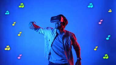 Mutlu dansçı VR gözlük takıyor ve havada süzülen notalarla şarkıya geçiyor. Dans ederken ve hareketli adımlar atarken sanal gerçeklik kulaklığı kullanan çekici bir adam. Aygıt.