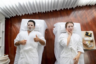 Kaplıca salonunun sakin, modern gündüz atmosferi, birkaç müşteri yüz maskesi takarak kendini yenilemeye çalışıyor. Yüz bakımı ve güzellik kozmetolojisi prosedürü. Sessiz.