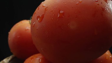 Macrography, tomatoes nestled within a rustic wooden basket are showcased against a dramatic black background. Each close-up shot captures the rich colors and textures of the tomatoes. Comestible. clipart