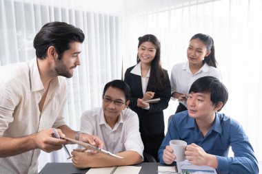 Bir grup farklı ofis çalışanı şirket ofis odasında stratejik iş pazarlama planlamasında birlikte çalışıyor. İş yeri konseptinde pozitif takım çalışması. Tedbirli