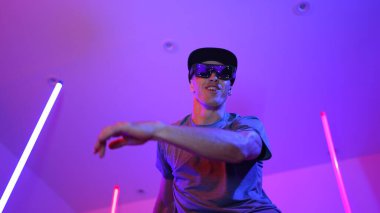 Beyaz dansçının gösterişli gözlükler taktığı ve break dans yaptığı alçak açılı kamera. Çekici adam kendinden emin bir şekilde kameraya bakarken enerjik bir performans ve hareket gösterdi. Mutluluk.