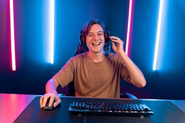 Kazanmak için çevrimiçi oyun oynayan akıllı flama makinesinin sunucu kanalı, neon ışıklı odada seçilen takım yarışması için izleyicilerle birlikte canlı yayında canlı yayında kulaklık takıyor. Bireysel.