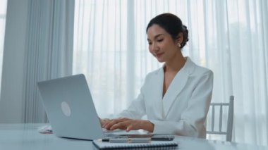 Çalışma masasında internet içeriği için dizüstü bilgisayar kullanan genç bir iş kadını ya da evden çalışan bir sekreter. Canlılık