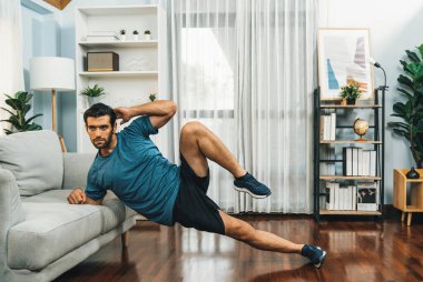 Atletik vücut ve aktif sporcu, sağlıklı vücut çalışma yaşam tarzı konsepti olarak neşeli ev egzersizlerinde kas kazanma egzersizi yapmak için mobilyaları kullanıyor..