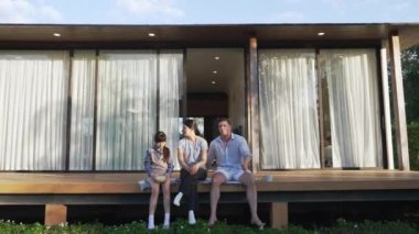 Şirin baba, anne ve kızı birlikte evin bahçesinde oturuyorlar. Ebeveynler, çevre farkındalığıyla ilgili genç nesli iletişim kurmak için açık hava aktivitelerini kullanırlar. Uyumsuzluk.