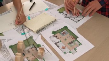 Akıllı mimar ya da akıllı mühendisin ölçüm aracı ve kalem el kullanarak mimari ofisindeki inşaat isabet planı üzerine detaylı bir yazı yazışının videosu. Eline odaklan. - Yakın çekim. Tanımlama.