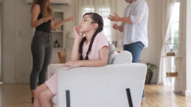 Sinirli ve mutsuz genç bir kız oturma odasında ebeveyninin tartışması yüzünden gerginliğin ortasında kanepede oturuyor. Sağlıksız ev hayatı ve travmatik çocukluk depresyona dönüşür.