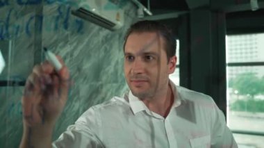 Profesyonel erkek lider yapışkan notlar üzerine pazarlama fikri yazıyor. Kafkasyalı işadamı cam duvarda renkli yapışkan notlar kullanırken pazarlama kampanyasını düşünüyor. - Yakın çekim. Yönlendirici.