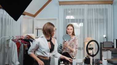 Etkilenen iki ortak canlı yayında video görüntülerini çekiyor makyaj malzemesi prim sosyal medya veya blog. Kozmetik stüdyosu ışıklandırmalı mutlu genç kız çevrimiçi pazarlama oturumu yayını için..