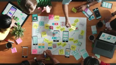 Profesyonel geliştirici ekip Ux Ui tasarımı fikrini zihin haritası kullanarak paylaşıyor. Bir grup iş adamının beyin fırtınası yapmak ya da cep telefonu arayüzü uygulamasını planlamak için birlikte çalıştıklarını görüyoruz. Cemaat.