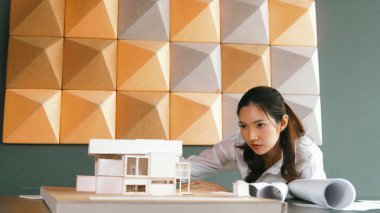 Ofisteki ev modelini kontrol ederken Asyalı profesyonel mimar kadın mühendisin portresi. Emlak evini kontrol ediyorum. İş tasarımı ve inşaat konsepti. Yönlendirici.