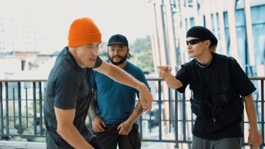 Modern alışveriş merkezinin koridorunda partner dans ederken hippi break dans yapıyor. Hip-hop müzik dansçısı ayak seslerini geliştirip müziğe yöneliyor. Açık hava sporu 2024. Aktif, enerjik dans. hiphop.