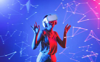 Beyaz VR kulaklık takan ve metaevreni birleştiren kolsuz tişört giyen, gelecekteki siber uzay topluluğu teknolojisi olan bir kadın siber punk neon ışığı altında el ve vücut hareketleriyle dans etmekten zevk alıyor. Halüsinasyon.