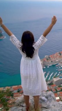 Hırvatistan 'ın önde gelen tatil beldesi olan Hırvatistan' ın Dalmaçya kentindeki Dubrovnik Eski Kasabası manzarasına bakan kadın turist. Dubrovnik eski kenti 1979 yılında UNESCO Dünya Mirasları Listesi olarak listelendi..