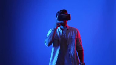 Sanal gerçeklik gözlüğünü açıp hologramı araklayan sıradan giysili profesyonel bir iş adamı. Üstveriye erişip girerken mavi arka planda duran yetenekli erkek model. Teknoloji. Aygıt.