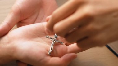 Yavaş çekimde kutsal haçı diğerine teslim etmek Katolik inancı dönüşümünün bir göstergesidir. Hristiyan takipçi diğerini dönüştürüyor. Aşkın ve fedakârlığın sembolü olarak haç ve İncil 'i veriyor. Filizlenen