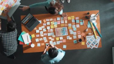 Tasarımcıların yapışkan notlar yapıştırıp renk paletlerine bakması. Yaratıcılığın birlikte çalışması ve başlangıç fikri ya da pazarlama planının notlarla birlikte masaya yatırılması. Sempozyum.