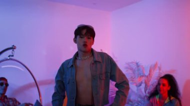 Çok kültürlü bir arkadaş kürsüde otururken Asyalı yetenekli bir dansçı modern müziğe geçiyor. Profesyonel dansçı, hipster takımı tezahürat yaparken ve desteklerken enerjik adımlar atıyor. Mutluluk.