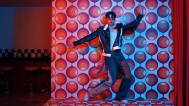 Asyalı break dansçı serbest stile geçiyor ve balon arka planlı kameraya bakıyor. Profesyonel hippi gündelik kıyafet giyer ve gözlük takar. Mutluluk.