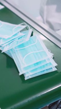 Modern fabrikada yüz maskesi üretim hattı. Covid-19 Coronavirus 2019 üretimi kavramı .