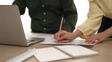 Mimar ve mühendis, modern ofisteki tablo üzerinde tasarım, ölçüm aracı ve plan için dizüstü bilgisayardaki taslak ayrıntılı taslak ile el yazısını karşılaştırıyor. - Yakın çekim. Tanımlama.