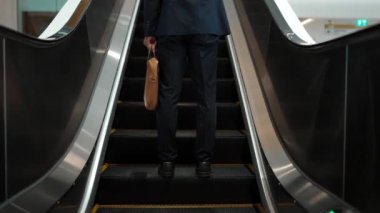 Yürüyen merdivenlerde duran zeki profesyonel iş adamının bacağı. Yetenekli proje yöneticisi terfi alıyor, yeteneğini arttırıyor, yükseltiyor, yeni bir pozisyon alıyor. Merkez. Bacağa odaklan. Sevinçli..