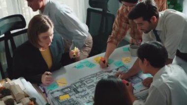 Proje planıyla masaya otururken bir grup farklı takım planlama stratejisi. Zeki iş adamlarının beyin fırtınası ve ev yapımı için birlikte çalıştıklarının en üst düzey görüntüsü. Hizalama.