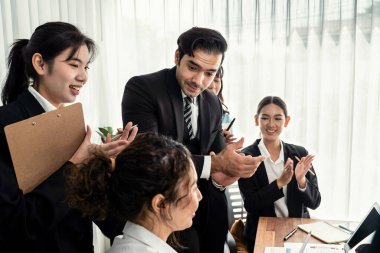 Kutlama jesti ve başarılı takım çalışması yapan bir grup mutlu iş adamı. Çeşitli yarış bürosu çalışanları şirket ofisinde pazarlama planlamasında ilerleme kaydettikten sonra kutlama yapıyorlar. Çok titiz.