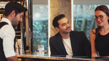 Güler yüzlü, VIP müşterileri içki tezgahında oturup barmenle konuştukları için davet eden ve ilk izlenimlerini harika yapan hoş geldin içkisi profesyonelliği hazırlayan çift. Vinosity.