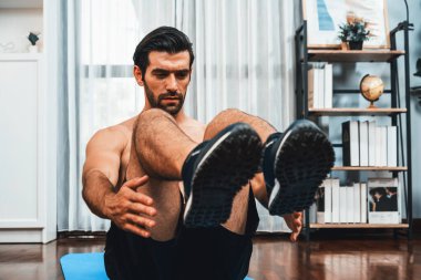 Atletik ve sporcu adam, evde vücut egzersizi yaparken spor ve spor yaşam tarzına uyum sağlamak için spor minderinde çatırdıyor. Gaiety ev egzersizi antrenman konsepti.