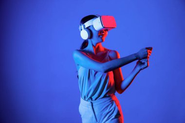 VR kulaklık takan zeki bir kadın metaevrene bağlanıyor, gelecekteki siber uzay topluluğu teknolojisi. Sanal sopayı hesaplayan ve kontrol eden zarif bir kadın ciddi ciddi golf oynuyor. Halüsinasyon.