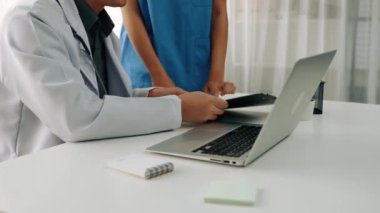 Hastane masasında birlikte çalışan ve tıbbi tedavi planlayan çeşitli profesyonel sağlık görevlileri. Takım çalışması başarılı hastalıklara ve hastalıklara yol açar. Ağır çekim. Katı.