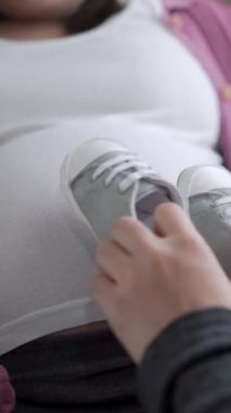 Hamile çift, evde sevgi hisseder ve rahatlar. Hamile bir kadın hamile karnında bebek taşıyor. Baba, hamile anneye göz kulak ol. Annelik ve hamilelik bakımı kavramı.