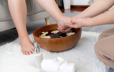 Kadınlar lüks spa salonlarında keyifli ayak masajlarına devam ederken, masör de hafif gün ışığı atmosferinde refleksoloji terapisi veya otel ayak spa 'sında. Sessiz.