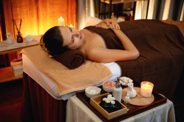 Beyaz kadın müşteri stres önleyici spa masajının keyfini çıkarıyor ve lüks otel ya da otelde sıcak mum ışığında güzellik teniyle eğleniyor. Sessiz.