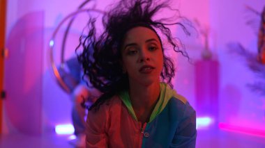 Çekici mutlu dansçı kameraya bakarken zeki kadın neon ışıkla kafiyeli hareket ediyor. Profesyonel İspanyol şarkıcı çeşitli arkadaşlarıyla renkli kıyafetler giyerken break dans yapıyor. Mutluluk.