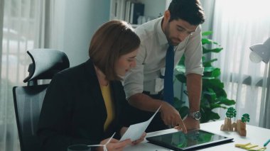 Profesyonel iş adamı, ESG 'nin çevresel yönetim tabletini kullanarak yöneticiye sürdürülebilir bir fikir sunuyor. Akıllı yönetici birlikte çalışarak temiz enerji kullanmayı planlıyor. Hizalama.