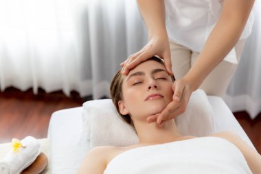 Kafkasyalı kadın stres önleyici kafa masajından ve lüks tatil beldesi ya da otel spa salonundaki modern ışık ortamında yüz güzelliği eğlencelerini şımartmaktan hoşlanıyor. Sessiz.